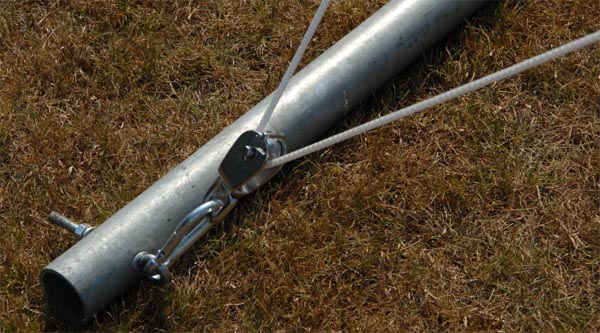 Stap 2 - Schroef de kikkers op de gewenste hoogte op de masten. Bevestig met een karabijnhaak de hijskatrol aan het oog van de mast en voer het touw losjes door de katrol.